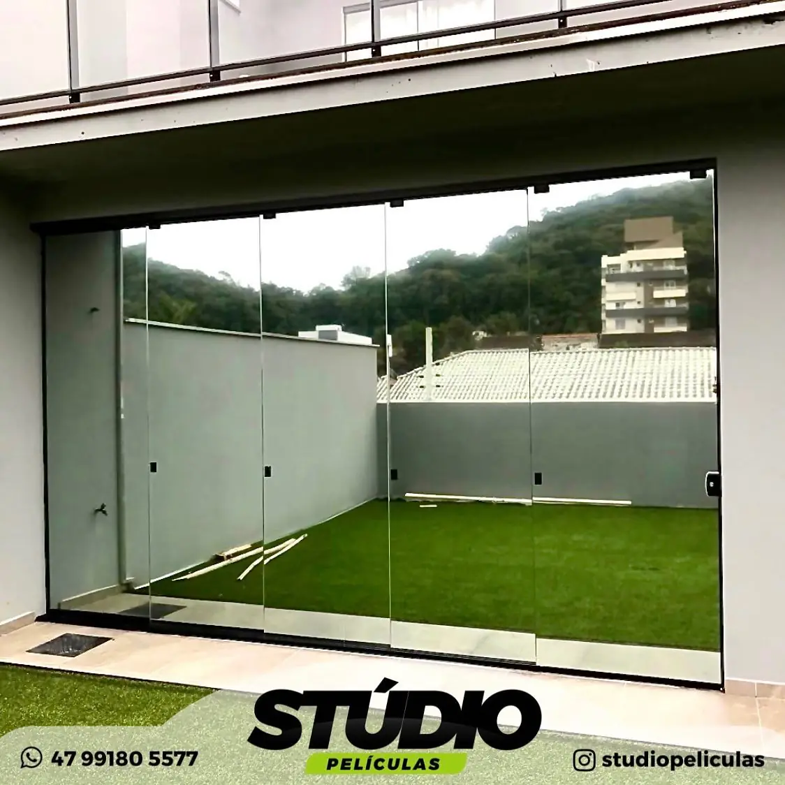 Porta de vidro de correr de residência com jardim, película residencial aplicada pela Stúdio Películas