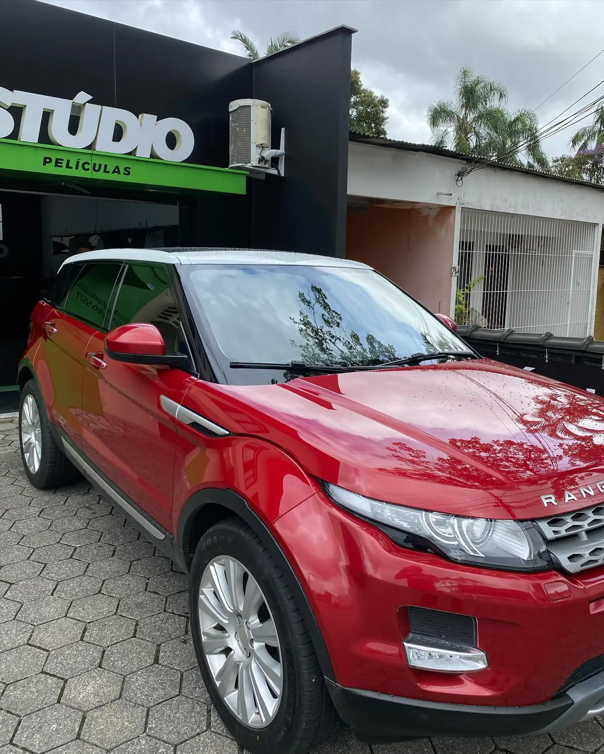 Range Rover Evoque vermelho com película automotiva em frente à Stúdio Películas, Joinville